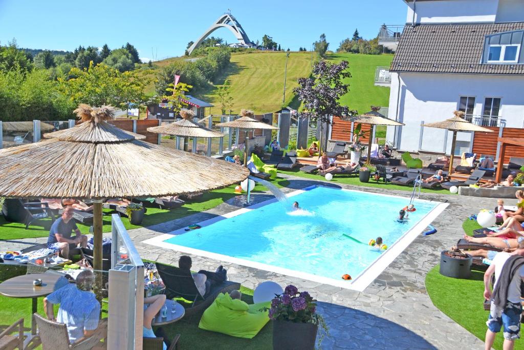 een groep mensen in een zwembad in een resort bij Vakantiehotel Der Brabander Apartments in Winterberg