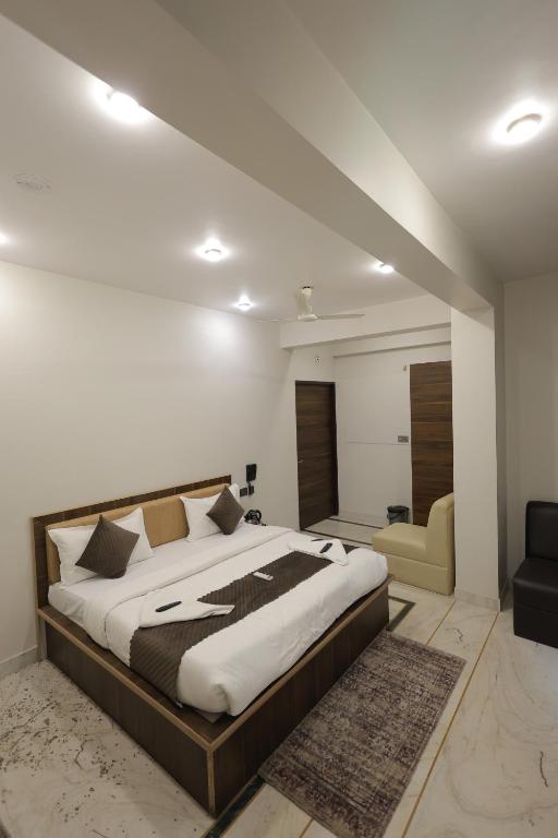 a bedroom with a large bed and a living room at Hotel Pearl -Jaipur Pink City Centre in Jaipur