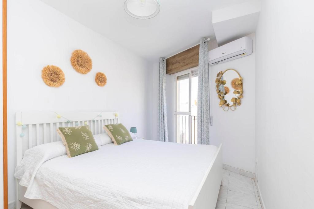 a white bedroom with a bed and a window at apartamento Cabo de Gata in El Cabo de Gata