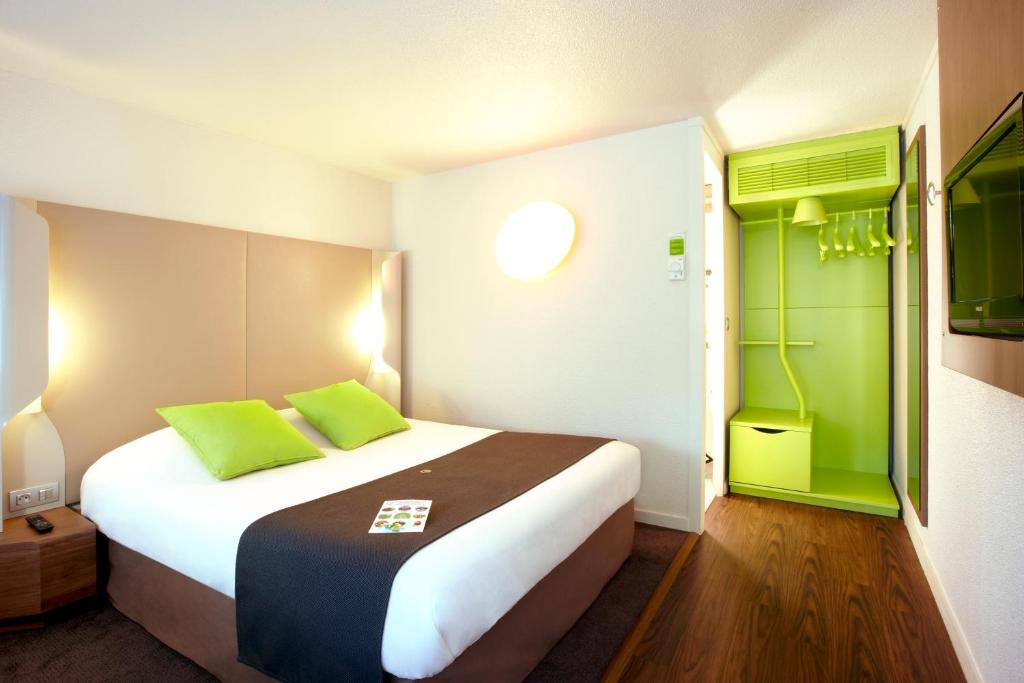 een slaapkamer met een groot bed met groene accenten bij Hôtel Campanile Orléans Nord - Saran in Saran