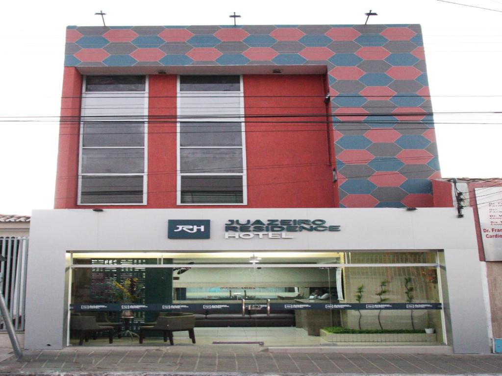 un magasin devant un bâtiment rouge et bleu dans l'établissement Juazeiro Residence Hotel, à Juazeiro do Norte