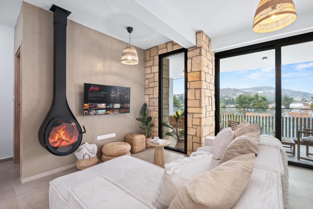 a living room with a couch and a fireplace at Pamboo TerraVine House by Nomads in Statos and Ayios Photios