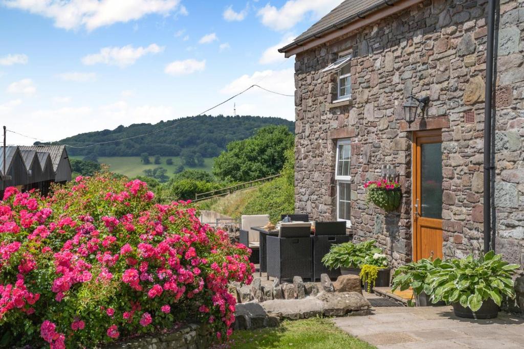 a stone house with flowers in front of it at 1 Bed in Nantygwreiddyn oc-bow49 in Sennybridge