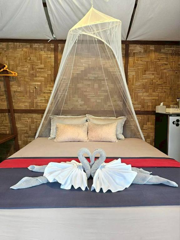 a bed with two towels in the shape of hearts at Phayam Local homestay in Ko Phayam