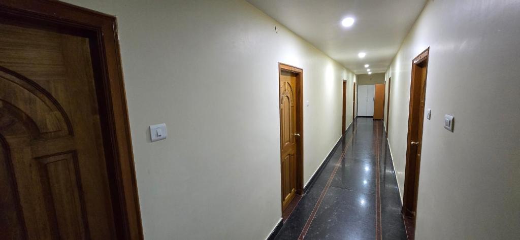 a hallway with two doors and a long hallway with a hallwayngthngthngthngth at Hotel KNR Grand in Srikalahasti