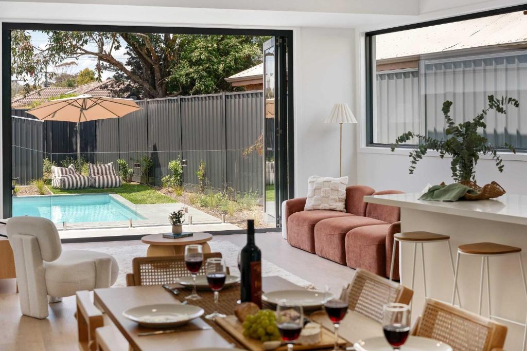 een woonkamer met een tafel met wijnglazen bij Poolside Luxury Villa - Solar Pool Beach 3min in Mornington