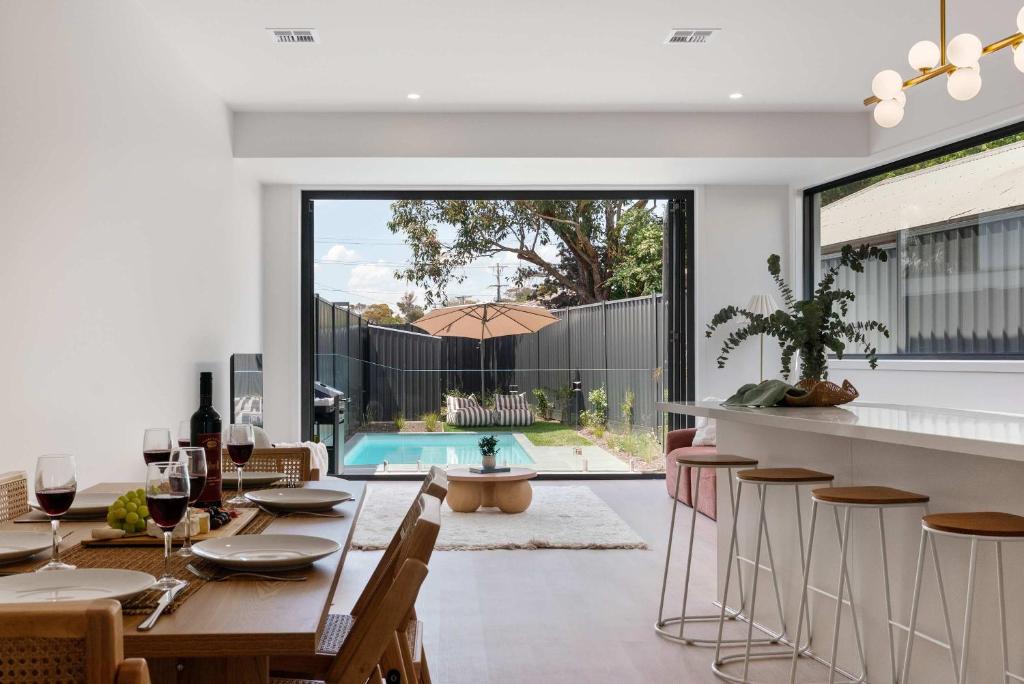 an open kitchen and dining room with a table and chairs at Poolside Luxury Villa - Solar Pool Beach 3min in Mornington