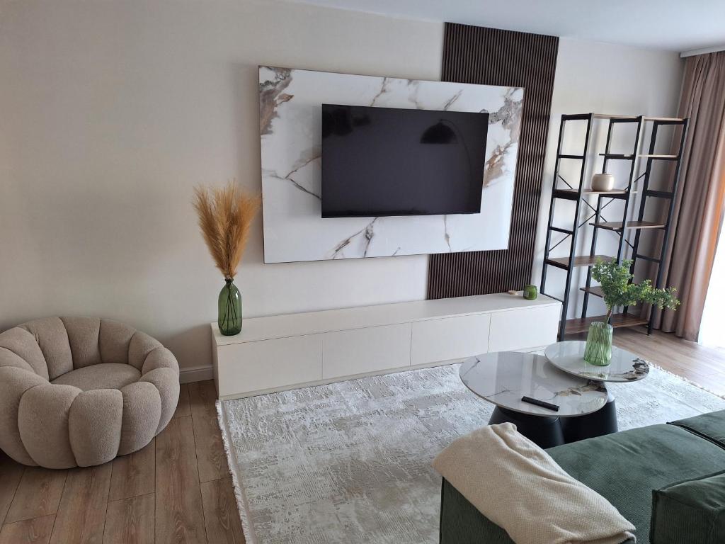 un soggiorno con una TV a parete di Mateo rezidence a Bistriţa
