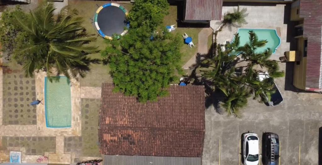 Elle offre une vue sur un jardin avec des arbres et une piscine. dans l'établissement Pousada Perolas de Itanhaem, à Itanhaém