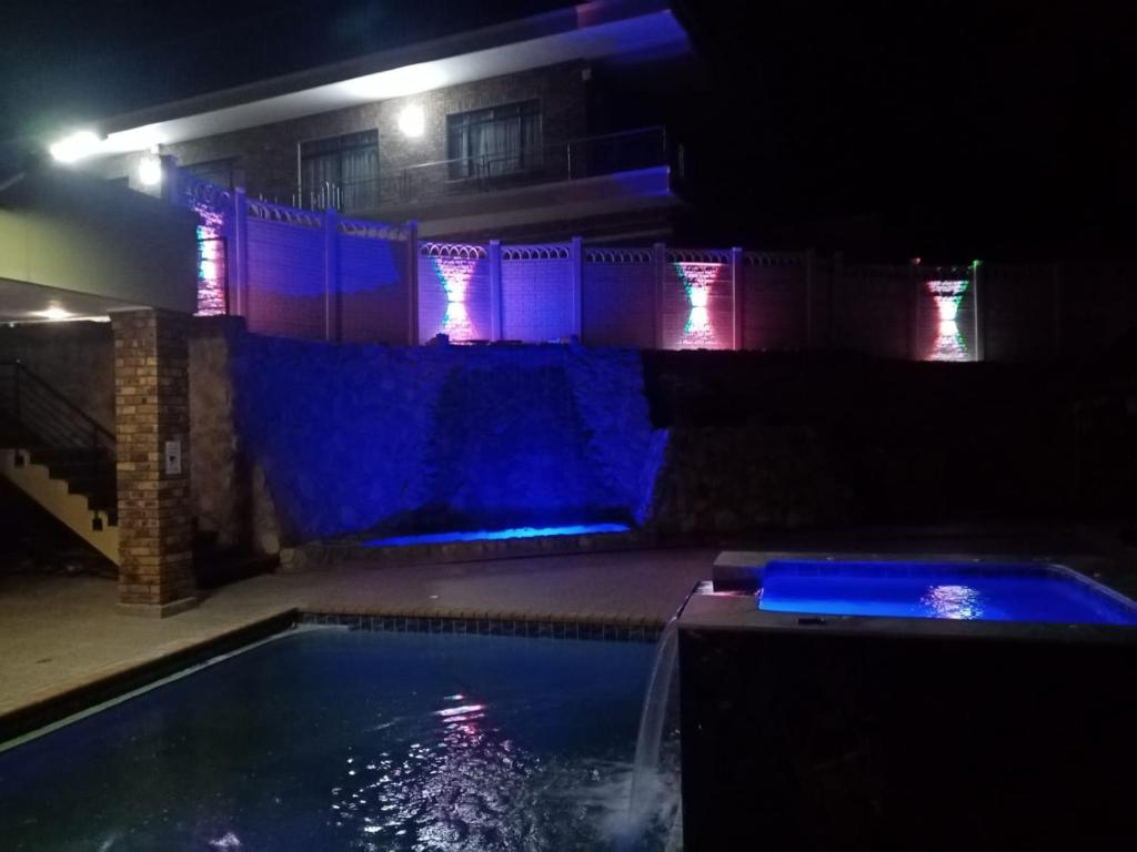 een zwembad 's nachts met blauwe lichten bij Pink Rock Villa in Durban