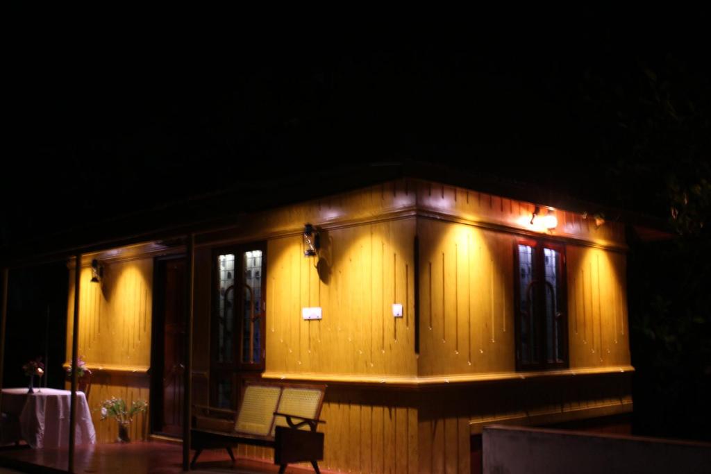 Una casa con una silla delante de ella por la noche. en Marari Beach Pearl Homestay, en Mararikulam