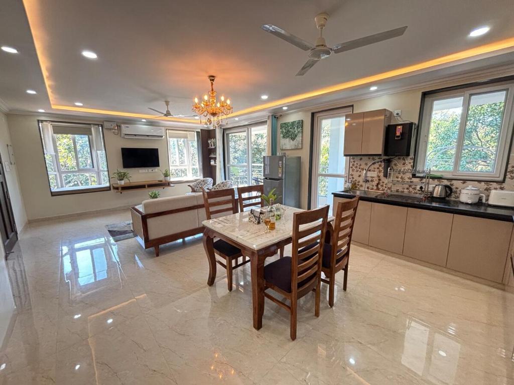 eine Küche und ein Esszimmer mit Tisch und Stühlen in der Unterkunft Monstera-Kudrat's Nilaya in Canacona