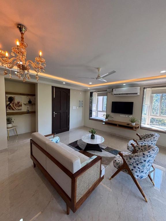 a living room with a couch and chairs and a tv at Monstera-Kudrat's Nilaya in Canacona