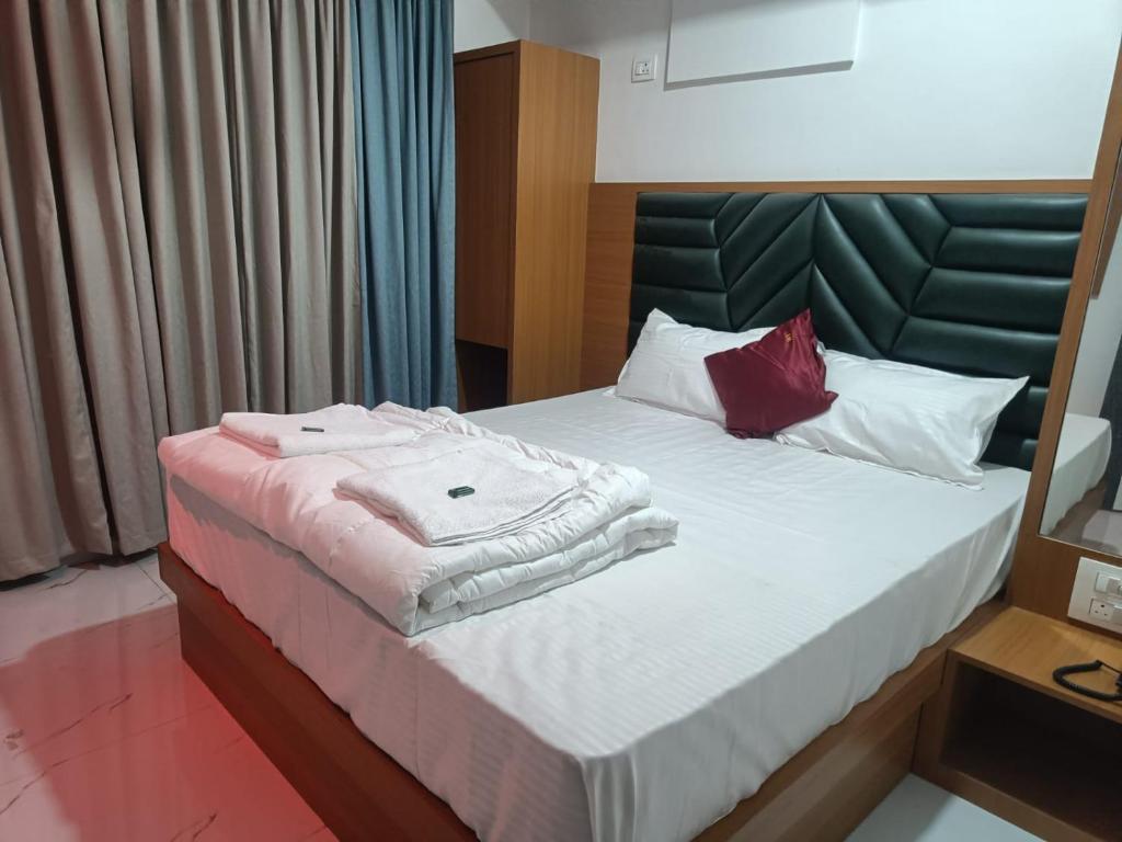 Un dormitorio con una cama con dos toallas encima. en The Lions Hotel, en Badlapur