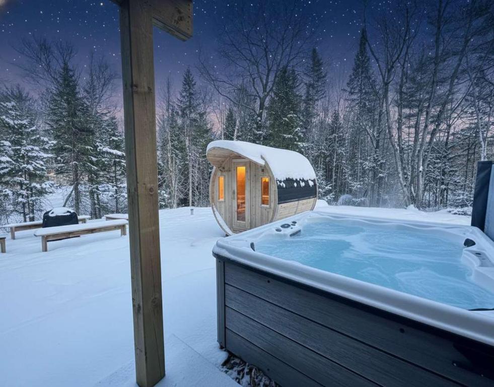 een jacuzzi in een met sneeuw bedekte tuin bij Foosball table Spa & Sauna - Sommetoile in Saint Come