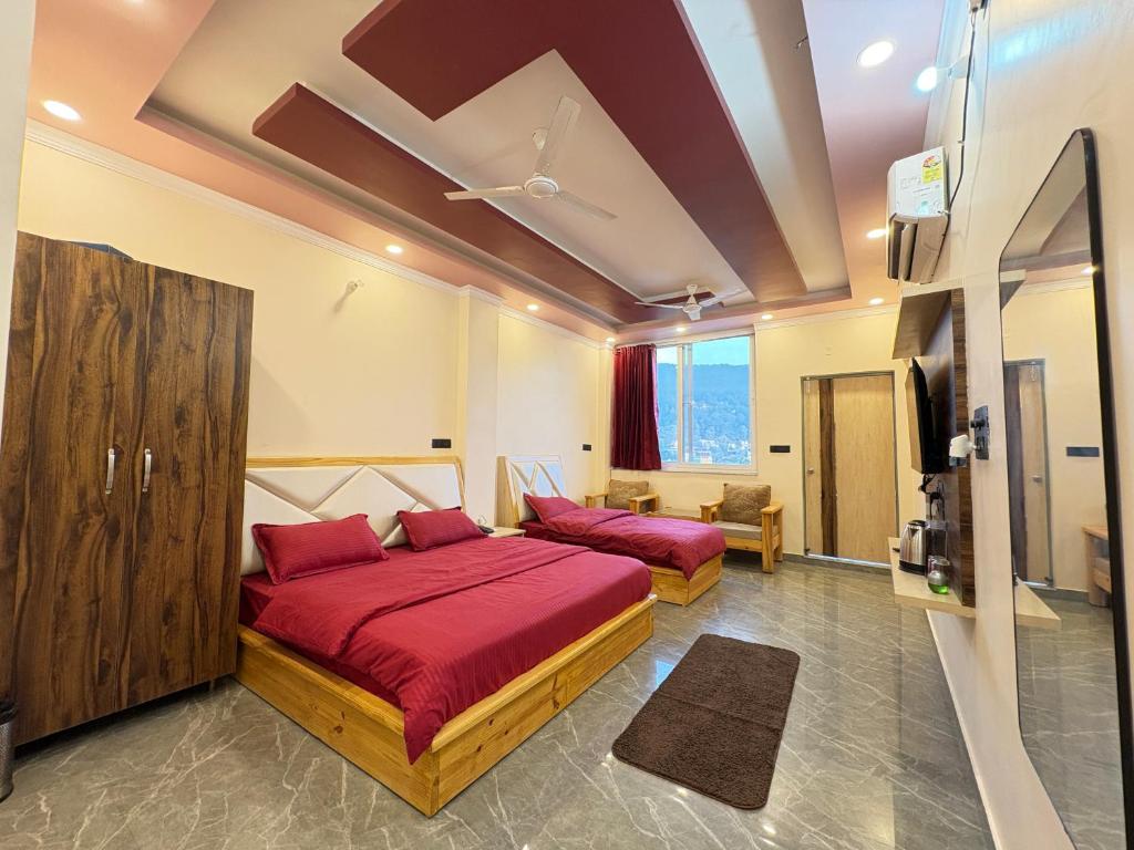 - une chambre avec 2 lits dotés de draps rouges et une télévision dans l'établissement Rivana Retreat, à Dehradun