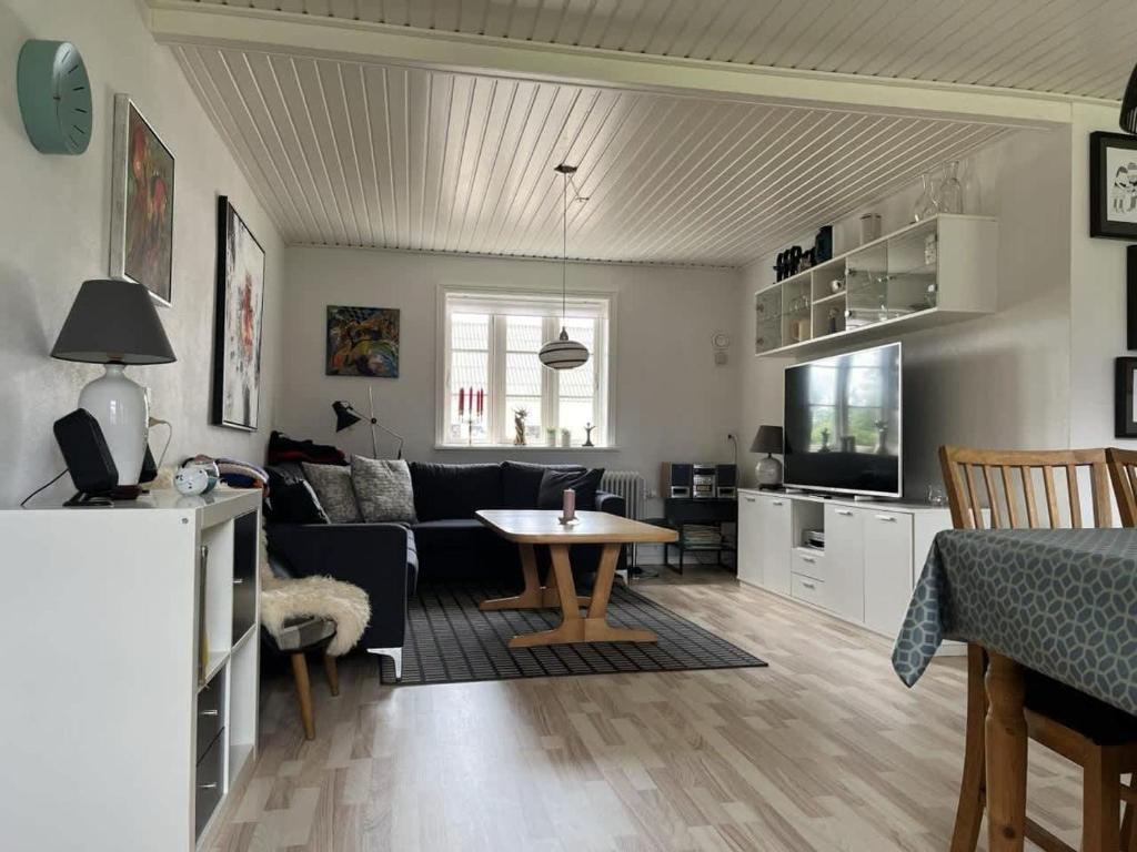 un soggiorno con un divano e un tavolo di Idyllic Countryside Farm with Horseback Riding a Borup