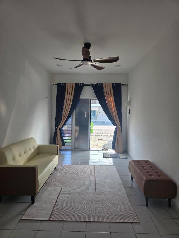 a living room with a couch and a ceiling fan at Homestay Zea in Gambang