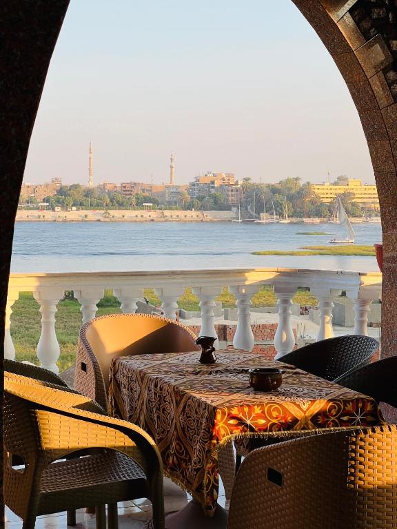a table on a balcony with a view of the water at Villa Set ma'at Nile view in Luxor