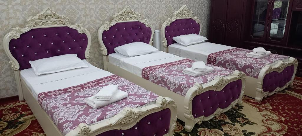 drie bedden in een kamer met paarse en witte meubels bij RegistanStay - Private House 2 Min Walk to Registan in Samarkand