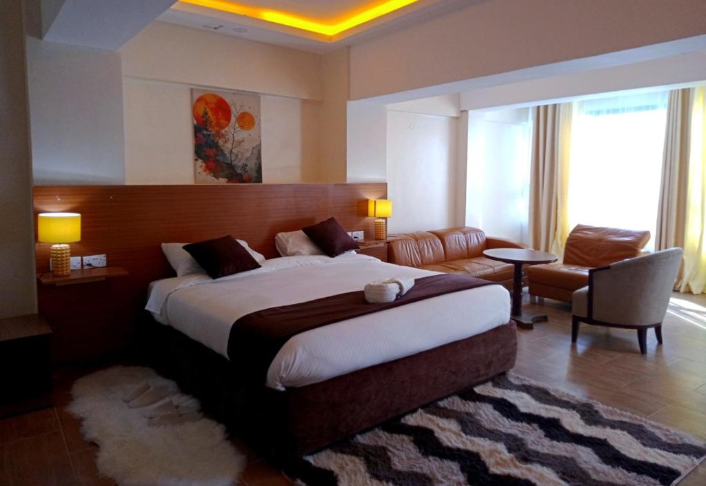 une chambre d'hôtel avec un grand lit et un canapé dans l'établissement Montage Luxury Hotel, à Kitengela 