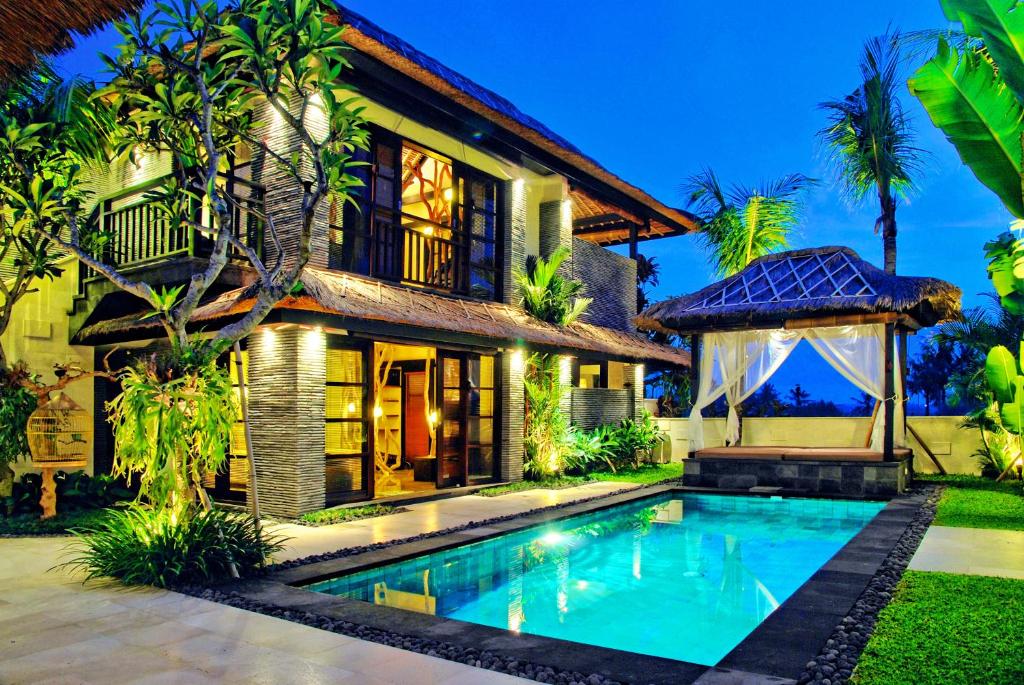 a house with a swimming pool in front of it at The Zala Villa in Canggu