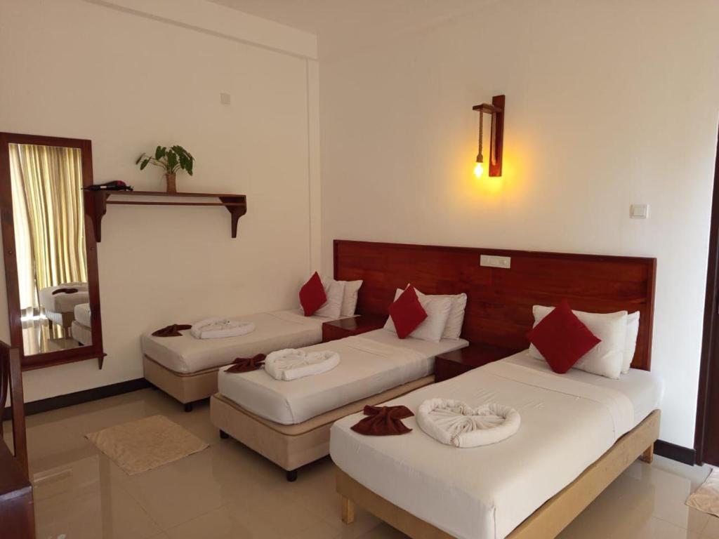 een hotelkamer met twee bedden en een spiegel bij Celestia by Sea Cloud in Talpe