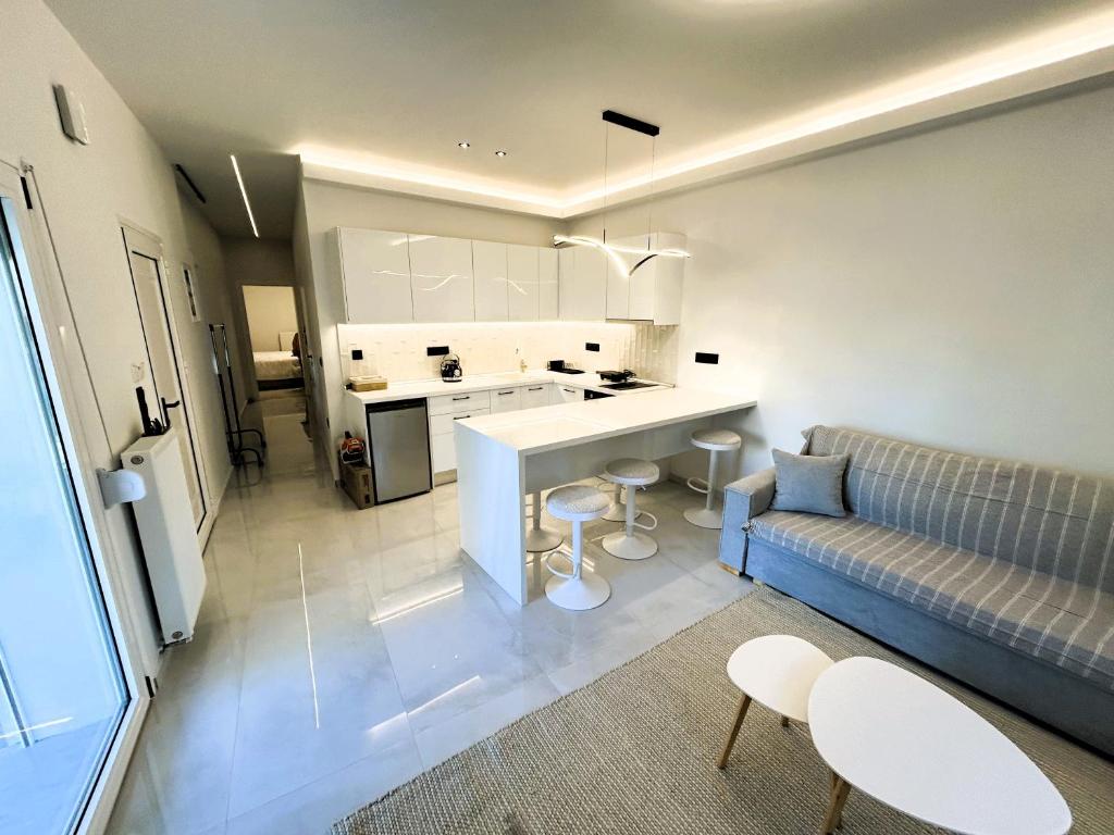 a living room with a couch and a kitchen at Ghini Venes 3 in Tríkala