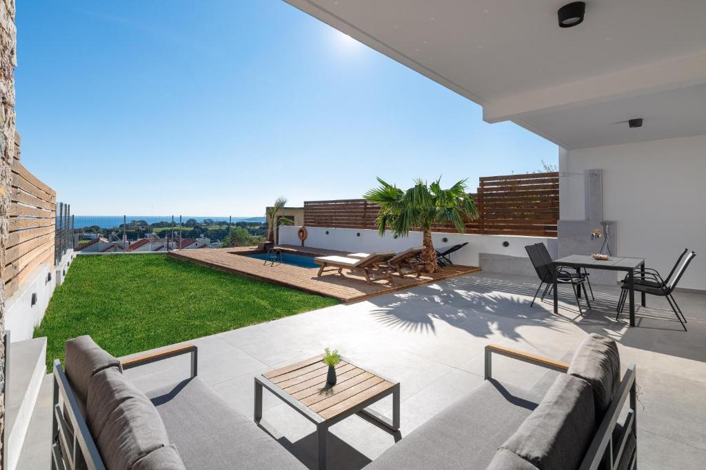 un patio con divano e tavolo su un edificio di Sea View Sunrise Luxury Apartment a Città di Rodi