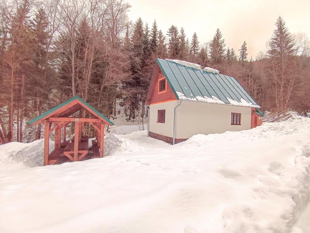 a red and white barn in the snow at Chata Bachláč, Jarabá in Jarabá