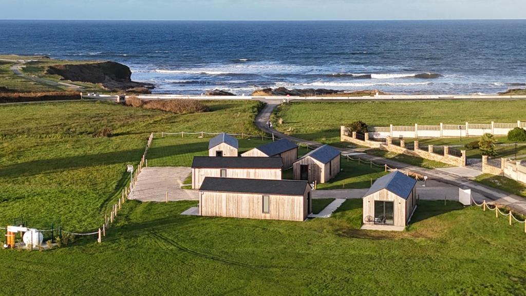 an aerial view of a house on a field near the ocean at Cabañas Camiño do Mar in Foz