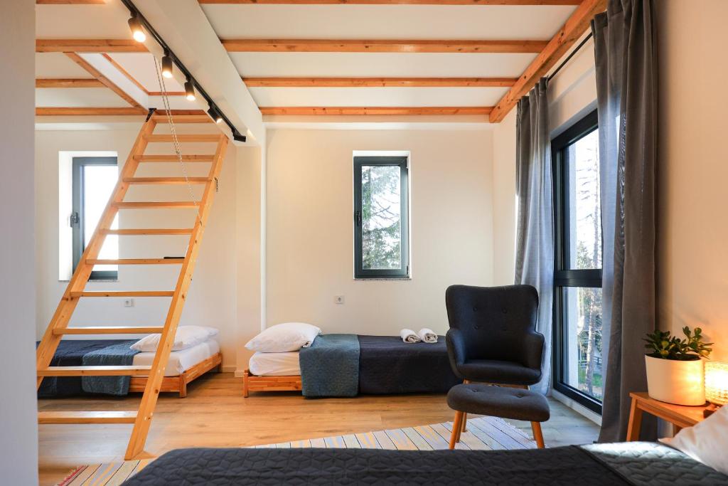 a room with a staircase and a bed and a chair at Viva Vlasic - Apartman i vikendica in Šišava
