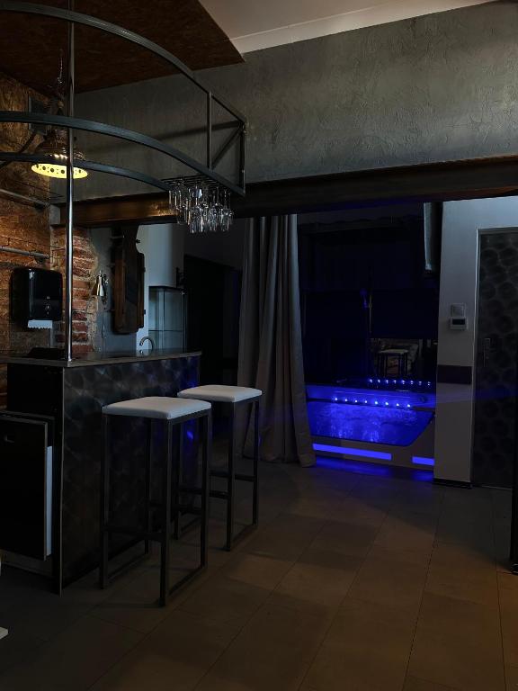 a kitchen with two bar stools and a blue aquarium at VIP Apart Gorlice in Gorlice