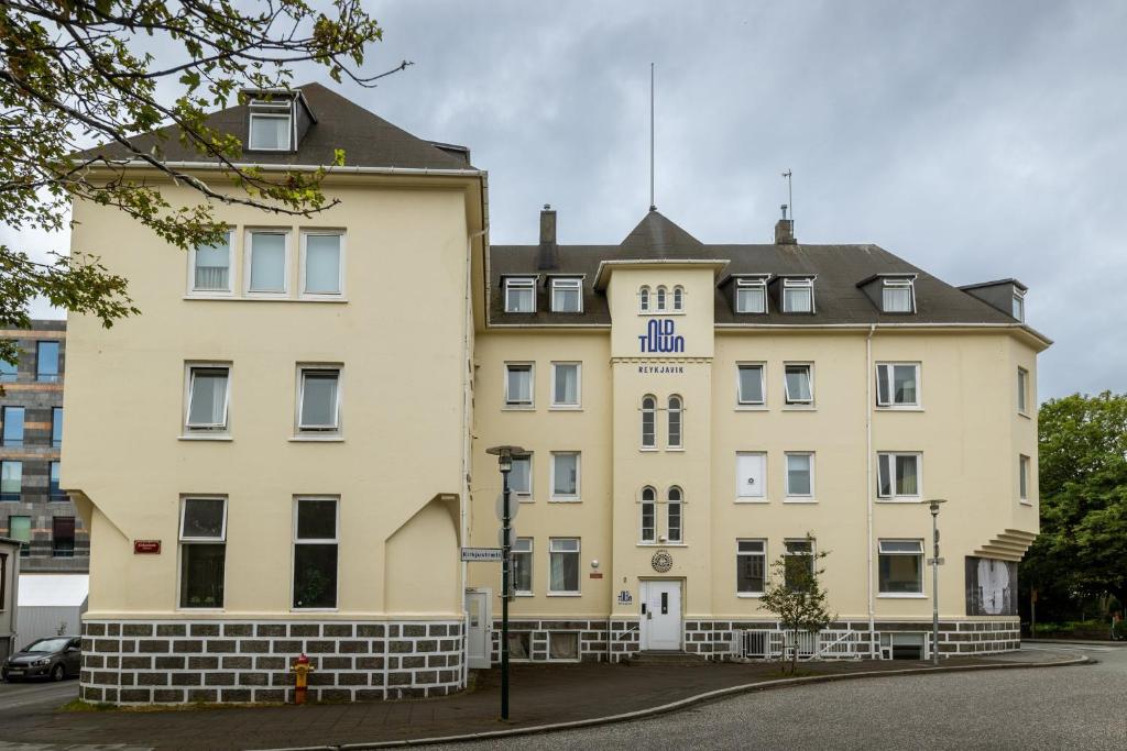 a large yellow building with a black roof at Old Town Reykjavik in Reykjavík