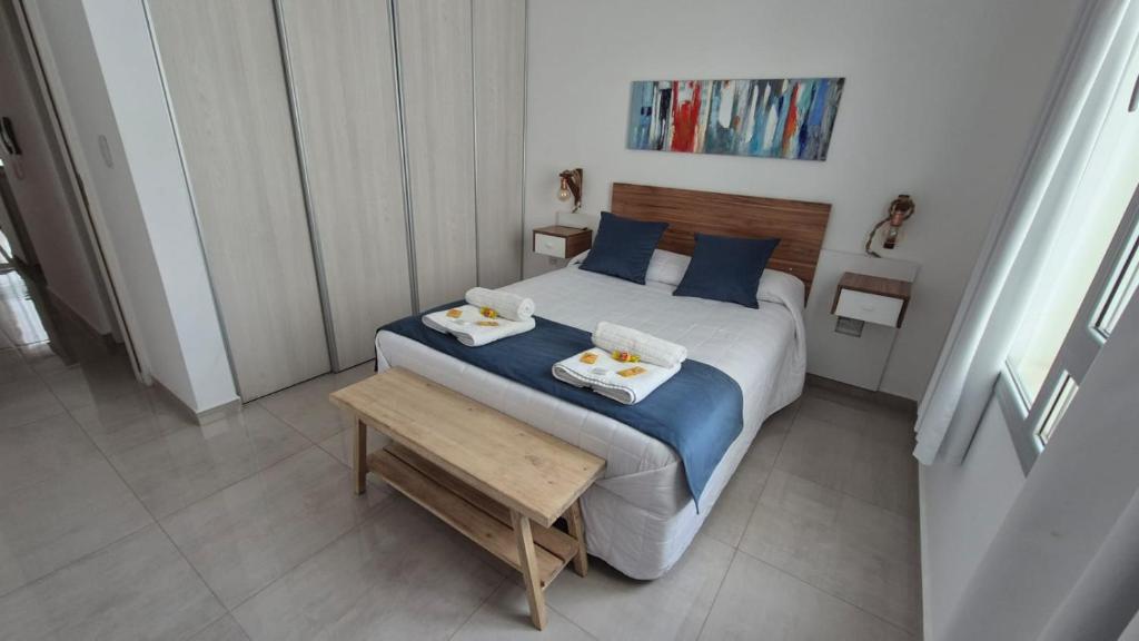 a bedroom with a bed with two towels on it at Departamento en el Centro in Puerto Madryn