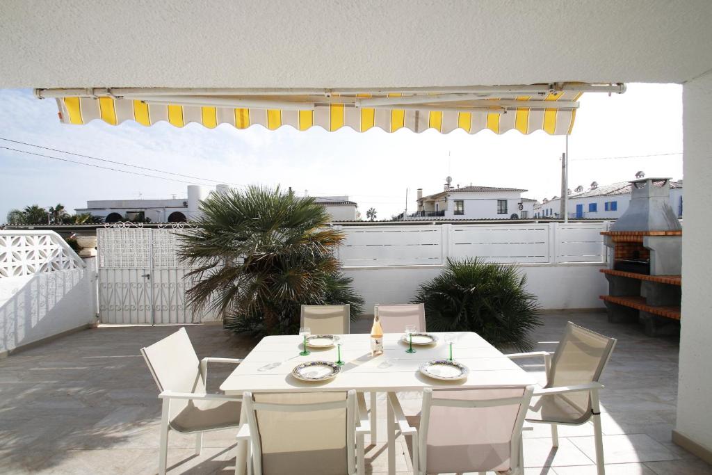Una mesa blanca y sillas en un patio. en Casa Lara, en Miami Platja