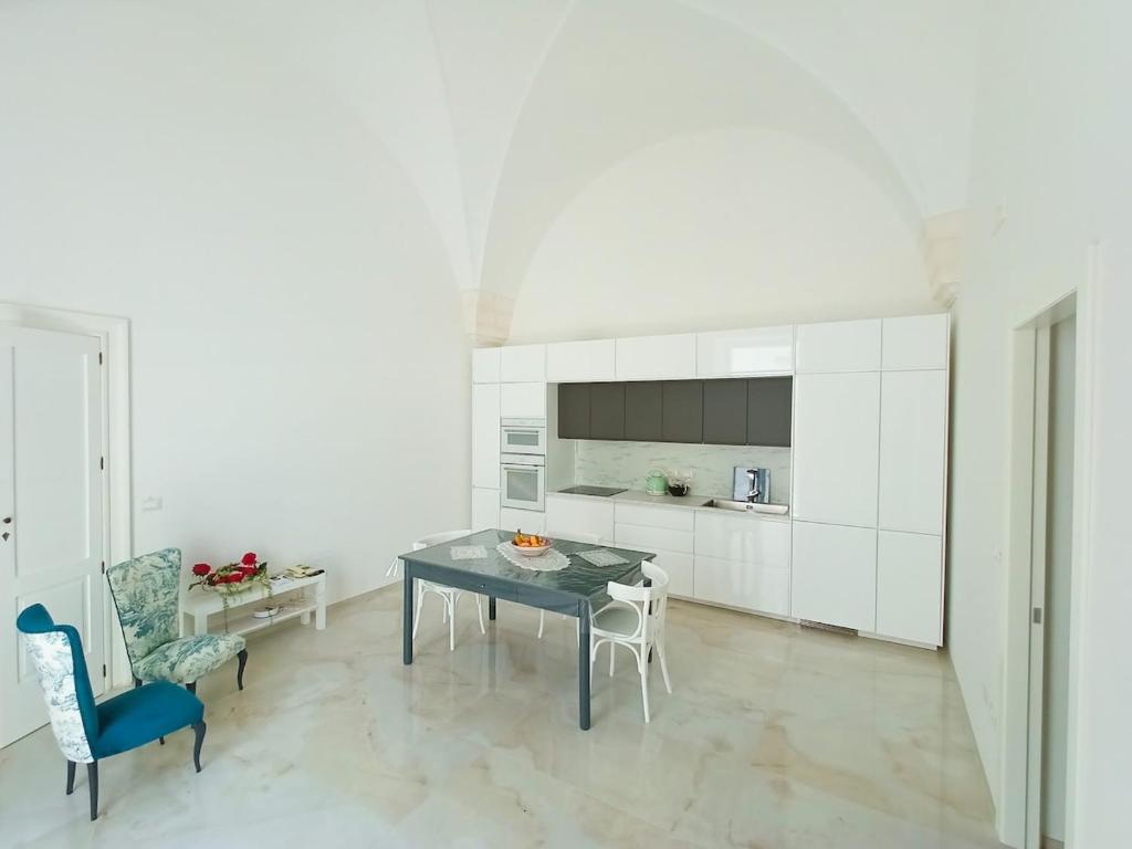 una cucina con un tavolo e sedie in una stanza di Piano B24 a Martina Franca
