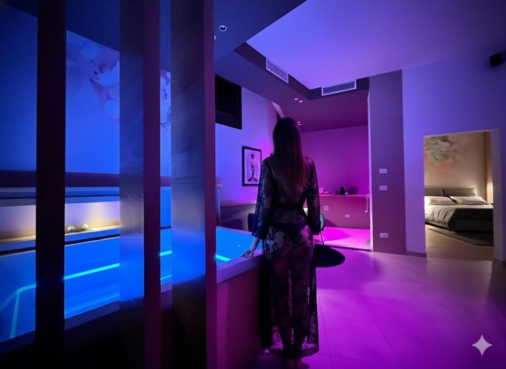 Una mujer parada en una habitación con luces moradas. en Sumaiè Suite - Wellness in Salento, en Mesagne