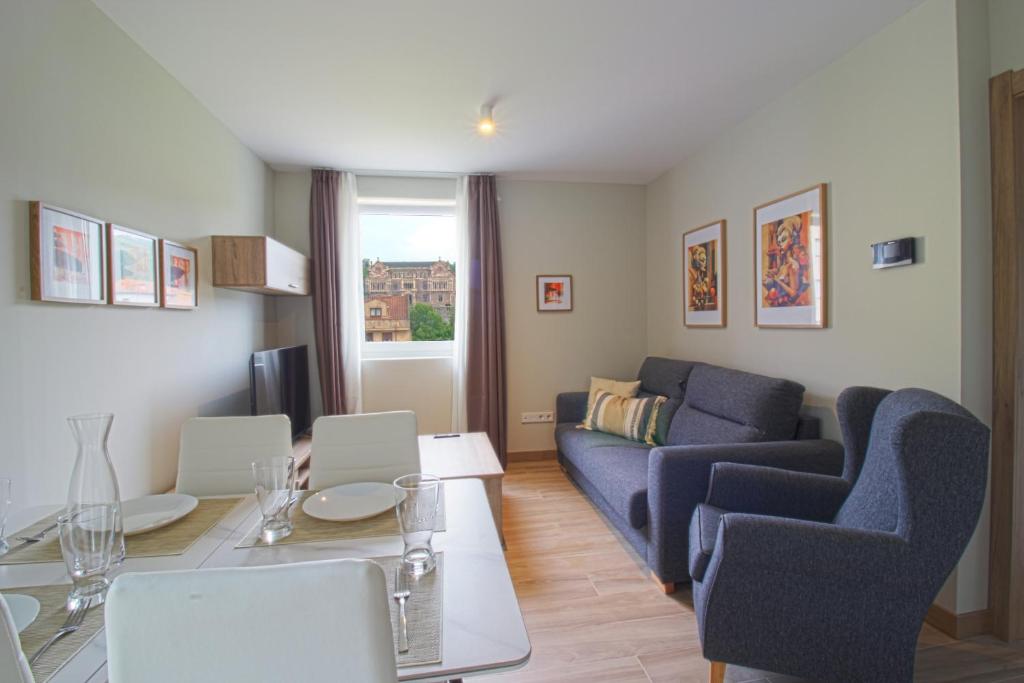ein Wohnzimmer mit Sofa und Tisch in der Unterkunft Apartamentos Turísticos La Pontificia in Comillas