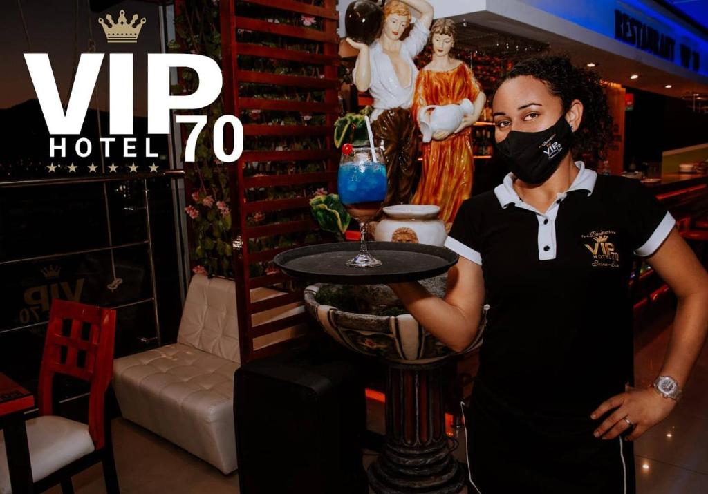 een jong meisje met een mondkapje dat een tafel vasthoudt bij Hotel Vip70 Jaen Perú in Jaén