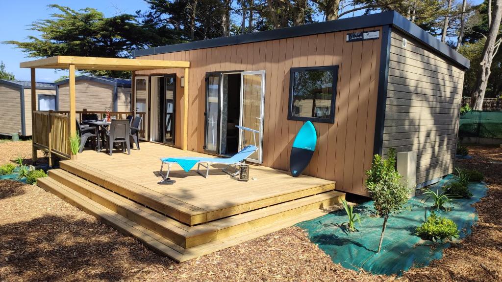 ein kleines Haus mit einer Terrasse und einem Tisch in der Unterkunft Le Beaupré - prestation hotelière in Mesquer