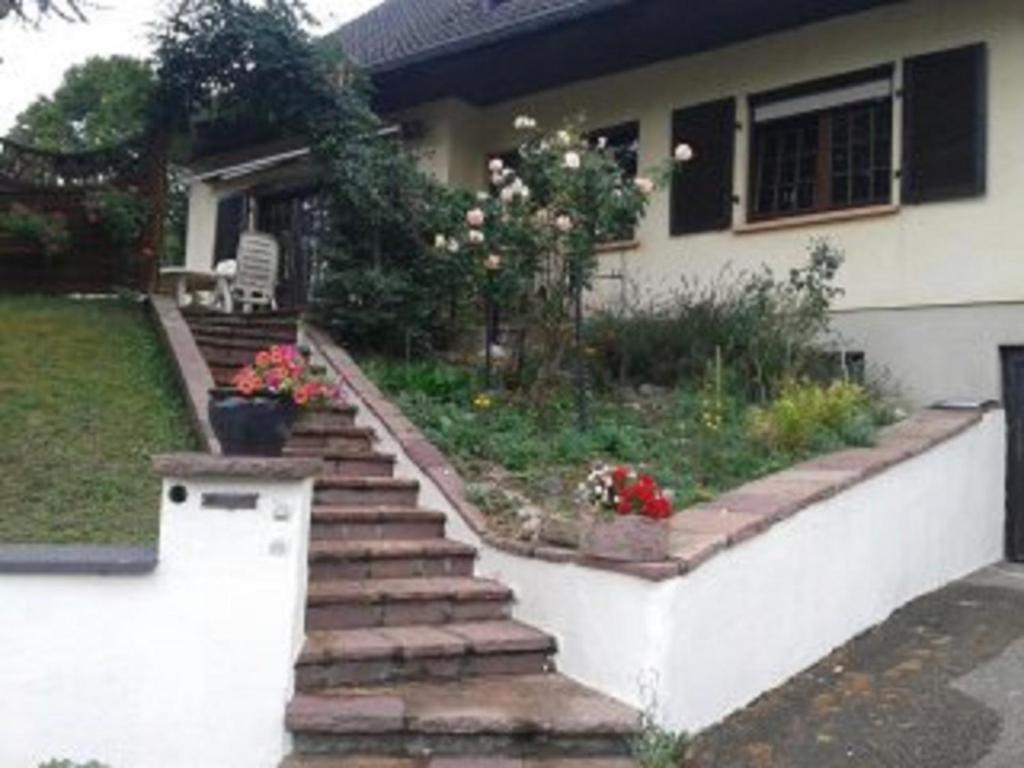 una casa con escaleras que conducen a un patio con flores en B&B Ma Maison Hautes Vosges en Ranspach