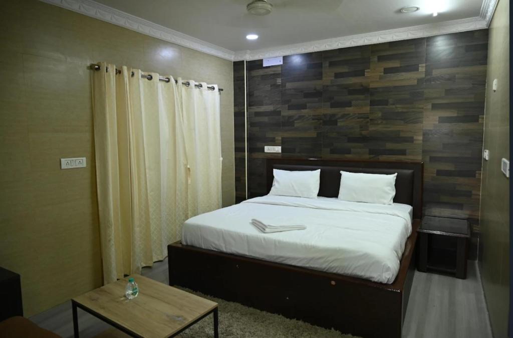 a bedroom with a bed with a wooden wall at Coromandel Suites in Chennai