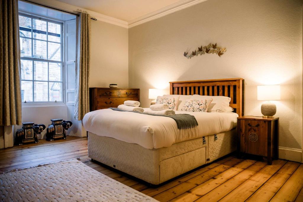 a bedroom with a large bed and a large window at 3 Bed Traditional Apartment on Picturesque Victoria St in Edinburgh