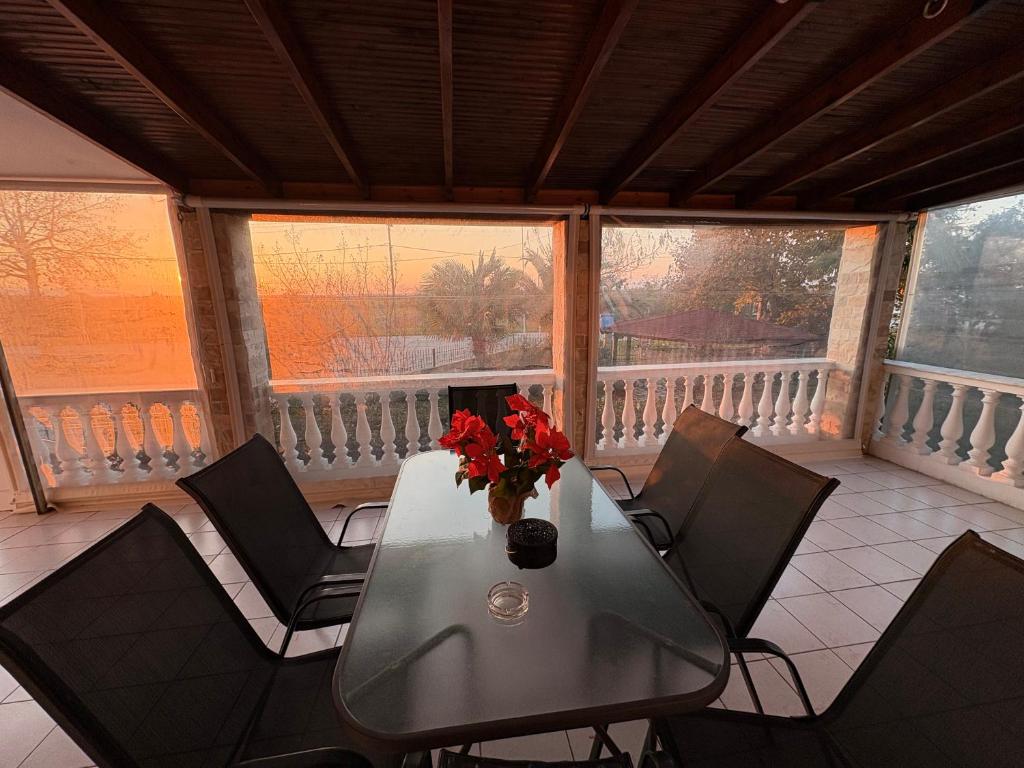 a table with chairs and a vase of flowers on a balcony at Villa Emara Mangana in Mángana