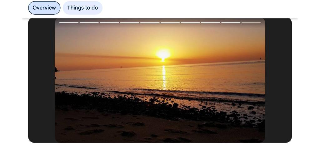 een iPad-scherm waarop een zonsondergang boven de oceaan te zien is bij Frankston Vacation Home in Frankston East