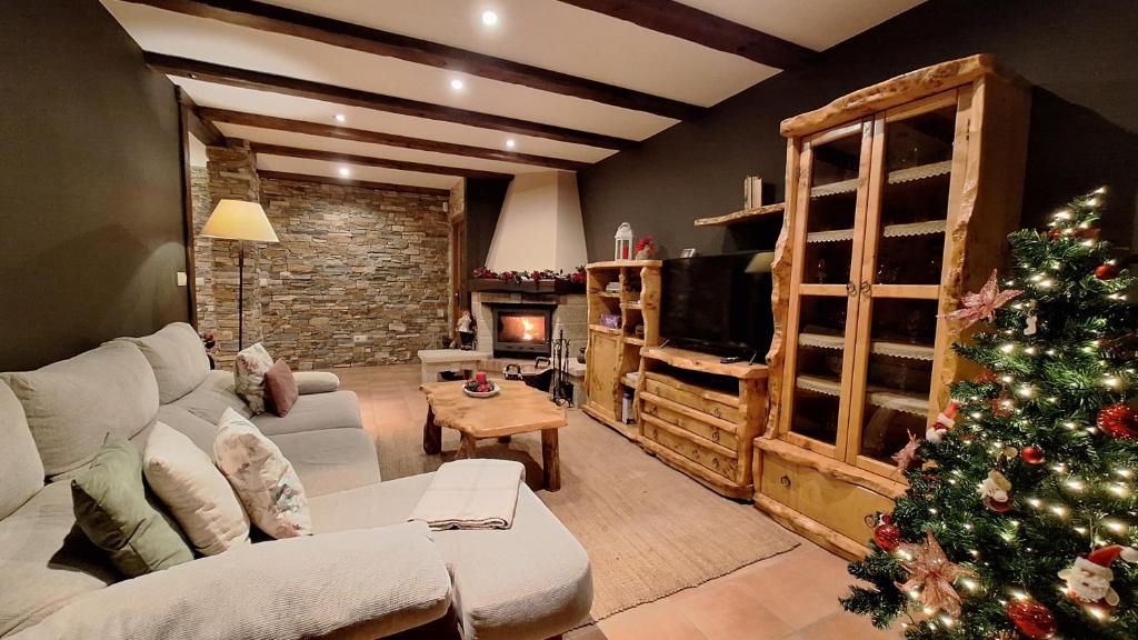 Una sala de estar con un árbol de Navidad y un sofá. en Chalet Rural Toñita 400 m playa piscina barbacoa chimenea, en Bueu