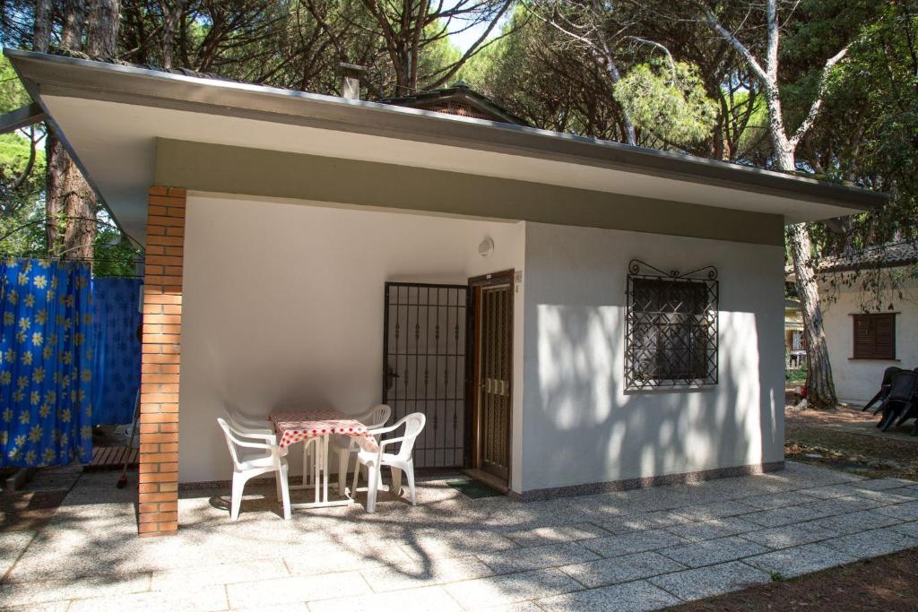 patio con tavolo e sedie sotto un capannone di Pine-front bungalow steps from the beach a Marina di Santa Croce