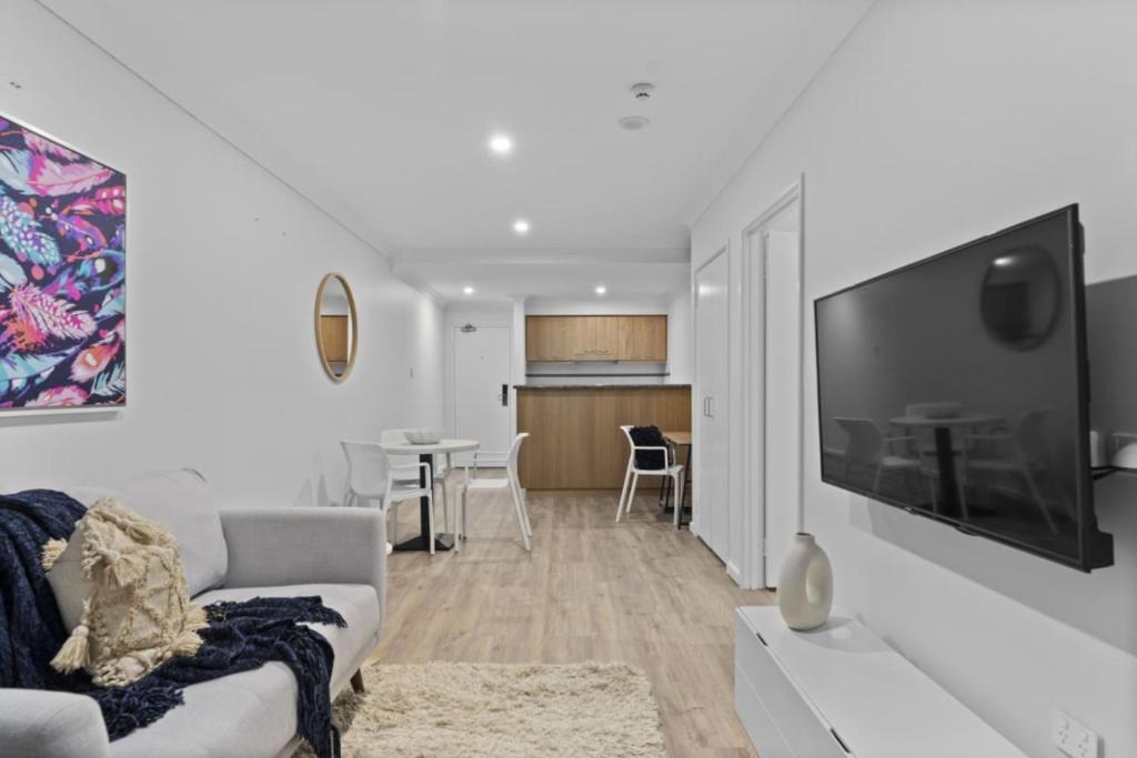 een woonkamer met een bank en een tv bij Cityscape on Mounts Bay in Perth