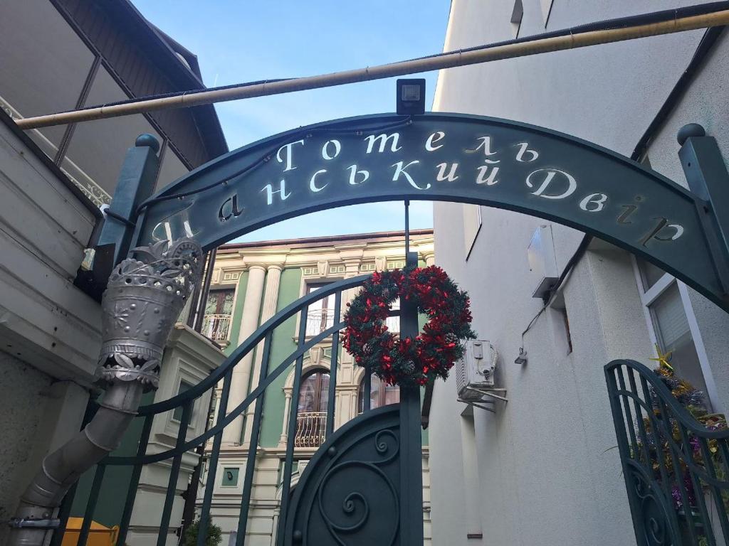 a sign for a building with a wreath on it at Панський Двір 2 in Chernivtsi